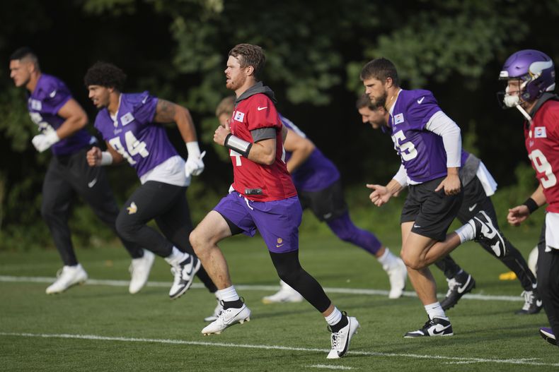Sam Darnold (14), centro, quarterback de los Vikings de Minnestoa, corre durante el entrenamiento del equipo de la NFL en The Grove en Watford, Inglaterra, el viernes 4 de octubre de 2024. (AP Foto/Kin Cheung)