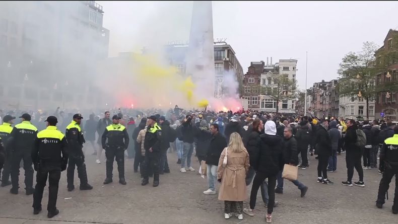 Foto tomada de video que muestra a la policía en guardia mientras partidarios del equipo de fútbol israelí Maccabi Tel Aviv prenden bengalas en la Plaza Dam en Ámsterdam, Holanda, el 7 de noviembre del 2024. (Foto AP InterVision)