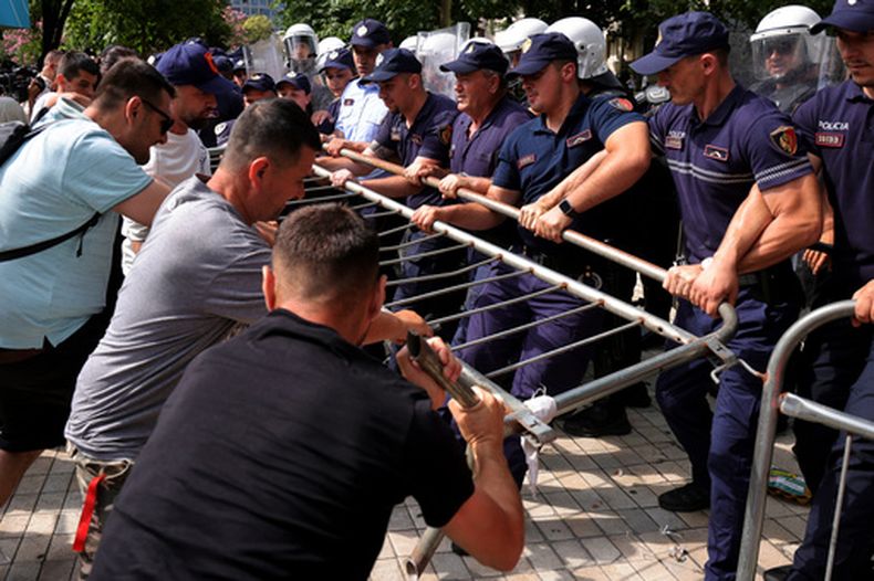 Manifestantes intentan retirar una barricada mientras la policía la sostiene durante una manifestación contra el gobierno en Tirana, Albania, el jueves 2 de julio de 2026. (AP Foto/Hameraldi Agolli)