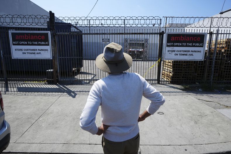 Un hombre frente a un negocio donde las autoridades de inmigración de EEUU llevaron a cabo una operación el viernes 6 de junio de 2025 en Los Ángeles. (AP Foto/Damian Dovarganes)
