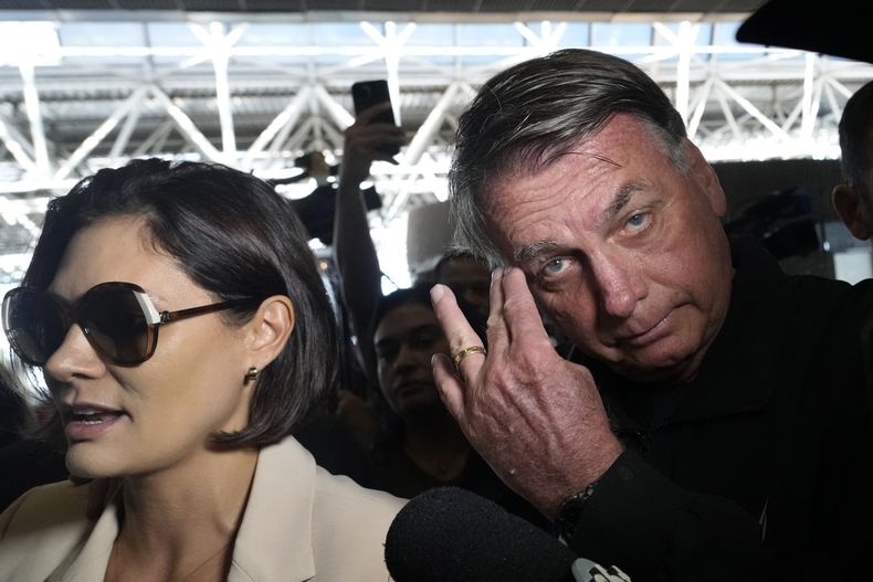 La exprimera dama de Brasil, Michelle Bolsonaro, llega acompañada por su esposo y expresidente, Jair Bolsonaro, al Aeropuerto Internacional de Brasilia, Brasil, el sábado 18 de enero de 2025, para abordar un vuelo a Estados Unidos para asistir a la toma de posesión del presidente electo de Estados Unidos, Donald Trump. (AP Foto/Eraldo Peres)