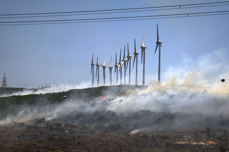 Un incendio arde cerca de unos molinos de viento en Cesme, cerca de Izmir, Turquía, el jueves 3 de julio de 2025. (Cengiz Malgir/Dia Photo vía AP)
