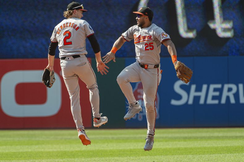 Gunnar Henderson (2) de los Orioles de Baltimore celebra junto al venezolano Anthony Santander (25) luego del juego de béisbol ante los Guardianes de Cleveland, en Cleveland, el domingo 4 de agosto de 2024. (AP Foto/Phil Long)