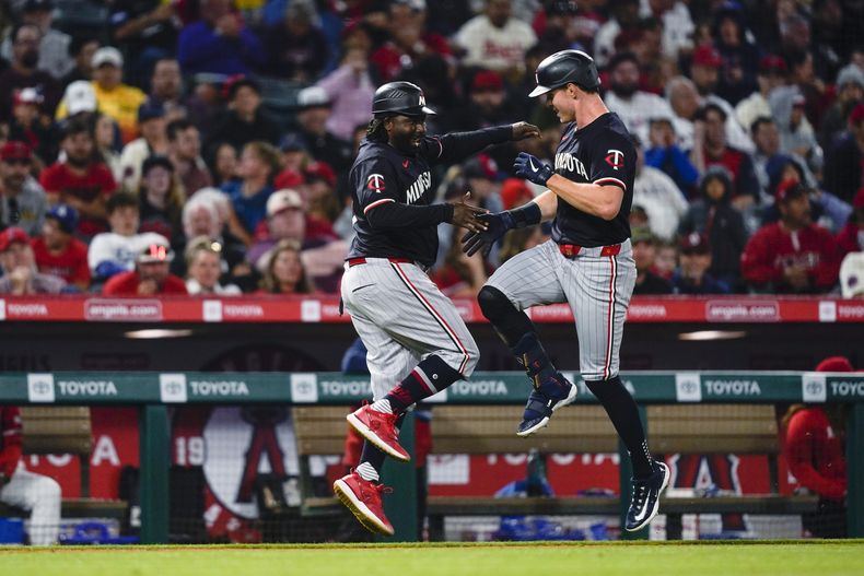 Max Kepler de los Mellizos de Minnesota celebra su jonrón solitario en la sexta entrada con el entrenador de tercera base Tommy Watkins en el juego ante los Angelinos de Los Ángeles el sábado 27 de abril del 2024. (AP Foto/Ryan Sun)