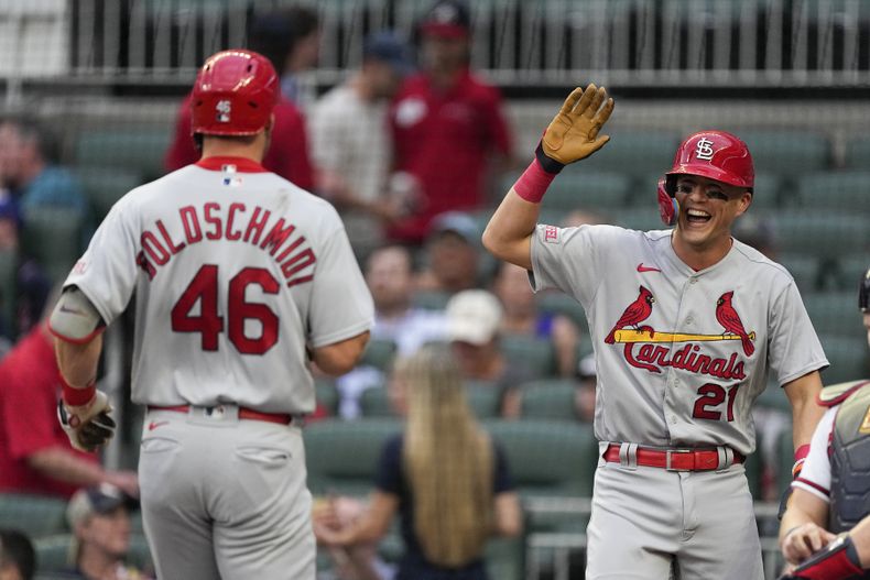 Lars Nootbaar (21), derecha, de los Cardenales de San Luis, reacciona mientras espera que Paul Goldschmidt (46) cruce el plato después del cuadrangular de dos carreras de Goldschmidt en la primera entrada del juego de béisbol en contra de los Bravos de Atlanta, el miércoles 6 de septiembre de 2023, en Atlanta. (AP Foto/John Bazemore)