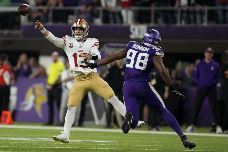 Brock Purdy (13), quarterback de los 49ers de San Francisco, lanza un pase ante la presión del defensivo de los Vikings de Minnesota D.J. Wonnum (98), durante la segunda mitad del juego de la NFL, el lunes 23 de octubre de 2023, en Minneapolis. (AP Foto/Abbie Parr)