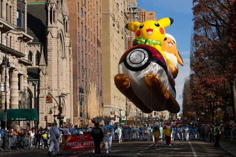 Manipuladores de globos guían el globo de Pikachu y Eevee por Central Park West durante el Desfile del Día de Acción de Gracias de Macys, el jueves 27 de noviembre de 2025, en Nueva York. (Foto AP/Frank Franklin)
