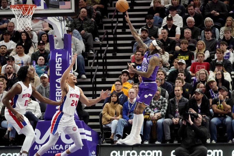 El escolta del Jazz de Utah Jordan Clarkson (00) dispara mientras James Wiseman (13) y Kevin Knox II (24) de los Pistons de Detroit defienden durante la segunda mitad del partido de baloncesto de la NBA el miércoles 3 de enero de 2024, en Salt Lake City. (AP Foto/Rick Bowmer)