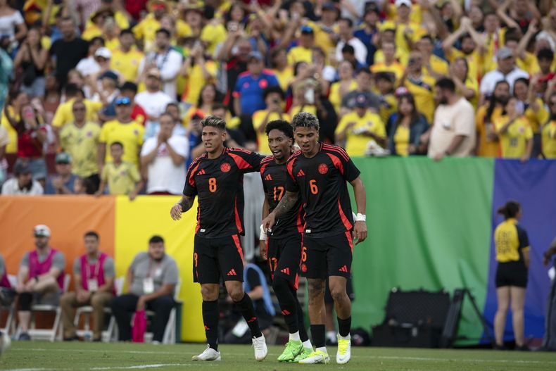 Jorge Carrascal (8), de la selección de Colombia, festeja con sus compañeros Johan Mojica (17) y Richard Ríos tras anotar ante Estados Unidos en un partido amistoso realizado en Landover, Maryland, el sábado 8 de junio de 2024 (AP Foto/Jose Luis Magaña)
