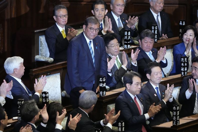Legisladores aplauden mientras el primer ministro, Shigeru Ishiba, de pie, es reelegido en una sesion parlamentaria especial en la cámara baja, el lunes 11 de noviembre de 2024, en Tokio. (AP Foto/Eugene Hoshiko)