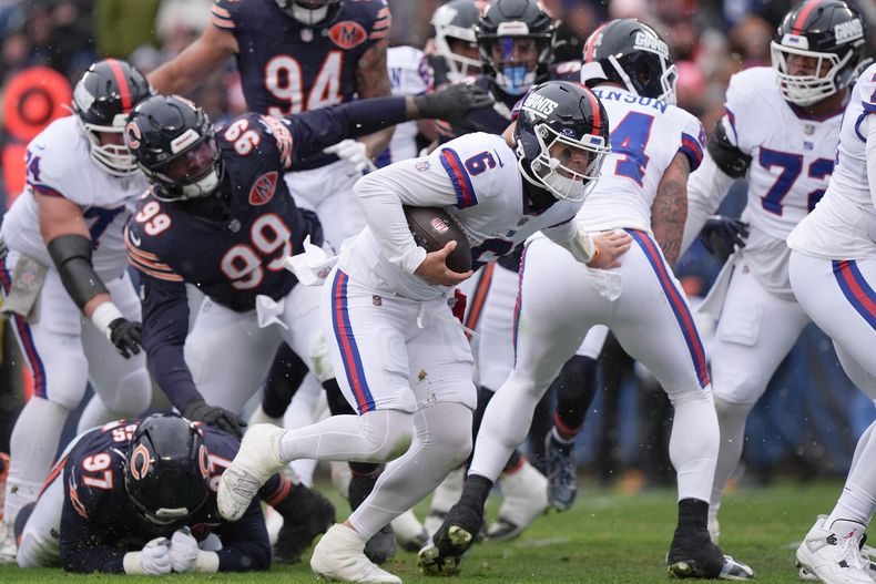 Jaxson Dart (6), quarterback de los Giants de Nueva York, supera la línea defensiva de los Bears de Chicago mientras corre para un touchdown durante la primera mitad del partido de la NFL el domingo 9 de noviembre de 2025, en Chicago. (AP Foto/Nam Y. Huh)