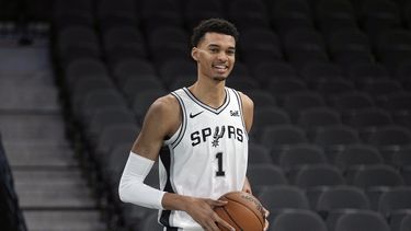 Victor Wembanyama, primera selección del draft de la NBA, escogido por los Spurs de San Antonio sostiene la bola durante una conferencia de prensa de la NBA en el AT&T Center en San Antonio. Sábado 24 de junio de 2023. (AP Foto/Eric Gay)