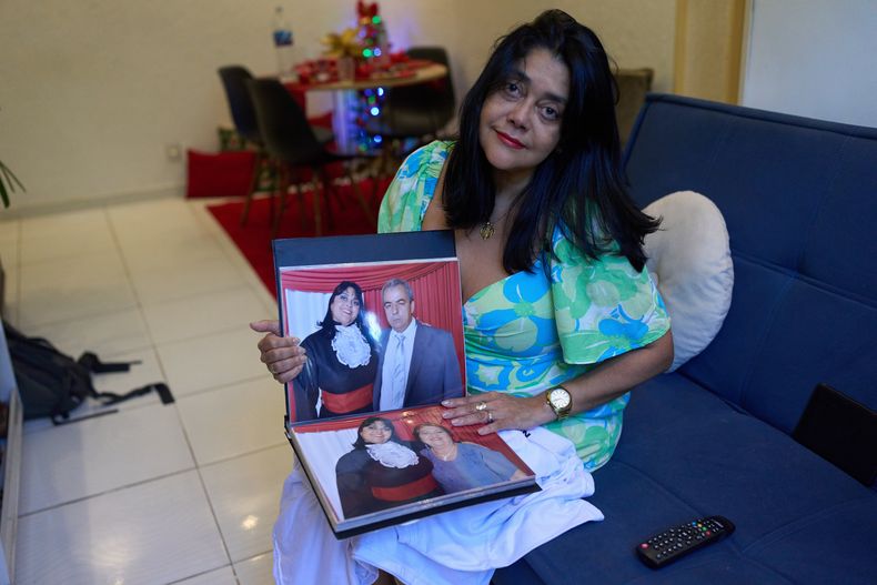 Simone Guimarães con una foto de ella y su esposo, quien murió de COVID, en su casa en Sao Goncalo, estado de Río de Janeiro, el 19 de noviembre del 2025. (AP foto/Silvia Izquierdo)
