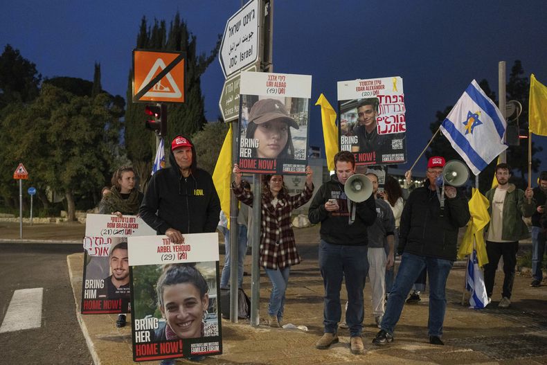 Manifestantes israelíes fuera de la oficina del primer ministro Benjamin Netanyahu con fotografías de Liri Albag y otros rehenes durante una protesta para exigir su liberación de manos del grupo miliciano Hamás, el domingo 5 de enero de 2025, en Jerusalén. (AP Foto/Ohad Zwigenberg)