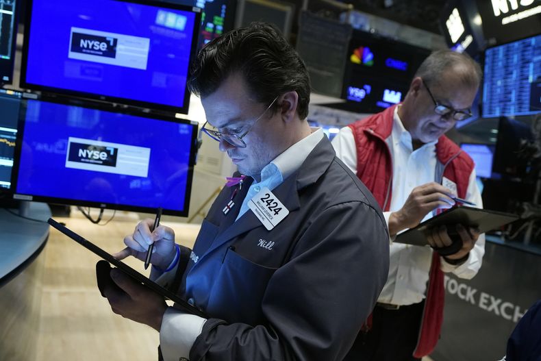 El agente Willian Leverick, a la izquierda, trabaja el jueves 30 de mayo de 2024 en el piso de remates de la Bolsa de Valores de Nueva York. (AP Foto/Richard Drew)
