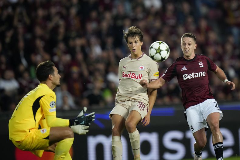 Tomas Wiesner, de Sparta, a la derecha, persigue el balón mientras John Mellburg, de Salzburgo, y Janis Blaswich, portero de Salzburgo, defienden durante el partido de fútbol de la fase inaugural de la Liga de Campeones entre Sparta de Praga y Salzburgo en Praga, República Checa, el miércoles 18 de septiembre de 2024. (AP Foto/Petr David Josek)