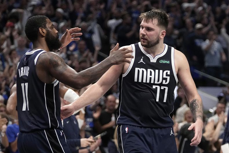 El armador de los Mavericks de Dallas, Kyrie Irving (11) celebra junto a su compañero Luka Doncic (derecha) el triunfo en el Juego 3 de la segunda ronda de playoffs de la NBA ante el Thunder de Oklahoma City, el sábado 11 de mayo de 2024, en Dallas. (AP Foto/Tony Gutierrez)
