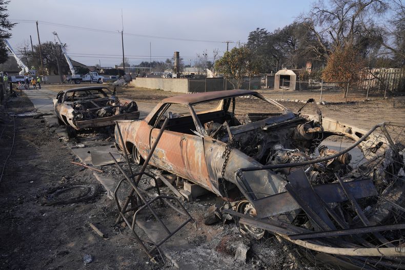 Trabajadores de la empresa de servicios públicos Southern California Edison intentan restablecer la electricidad en el área destruida por el incendio Eaton, el domingo 19 de enero de 2025, en Altadena, California (AP Foto/Damian Dovarganes, Archivo)