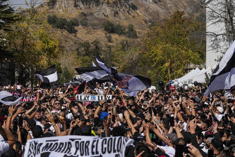 Hinchas de Colo Colo y familiares de dos aficionados fallecidos en una estampida en el estadio la semana anterior celebran un homenaje por el centenario del club en Santiago, Chile, el sábado 19 de abril de 2025. (Foto AP/Esteban Félix)