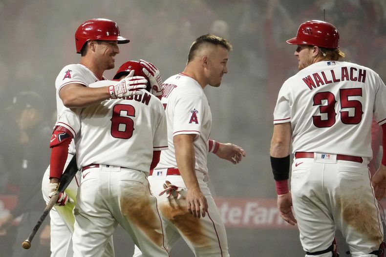 Zach Neto (izquierda), de los Angelinos de Los Ángeles, festeja luego de anotar la carrera del triunfo sobre los Rangers de Texas, el viernes 5 de mayo de 2023 (AP Foto/Mark J. Terrill)