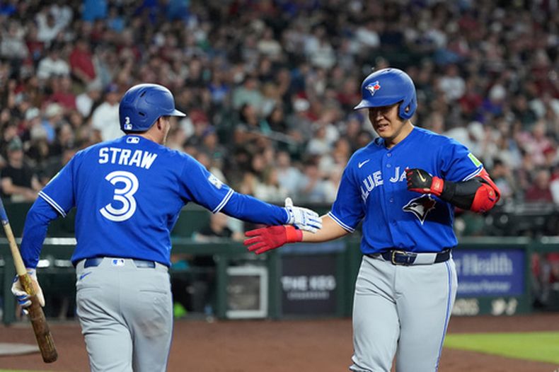 Kazuma Okamoto, de los Azulejos de Toronto, a la derecha, de Japón, celebra su jonrón contra los Diamondbacks de Arizona con Myles Straw (3), también de los Azulejos, durante la tercera entrada de un juego de béisbol, el domingo 19 de abril de 2026, en Phoenix. (AP Foto/Ross D. Franklin)