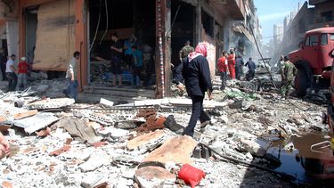 americateve | Fotograf&iacute;a distribuida por la agencia oficial de noticias siria SANA que muestra a habitantes del distrito de Zahra en la ciudad de Homs, revisando los da&ntilde;os causados por un ataque con morteros el martes 29 de abril de 2014. (Foto de AP/SANA