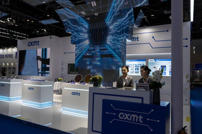 ARCHIVO - Trabajadoras en un puesto del productor chino de DRAM ChangXin Memory Technologies, también conocido como CXMT, esperan a visitantes en la 21ra Expo Internacional de Semiconductores de China en Beijing, el 20 de noviembre de 2024. (AP Foto/Ng Han Guan, Archivo)