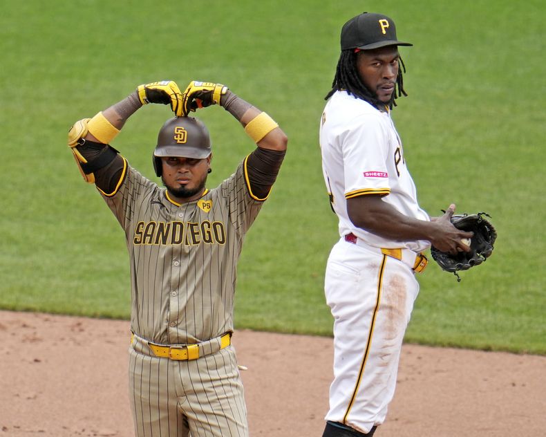 El venezolano Luis Arráez, de los Padres de San Diego, festeja de pie en la intermedia, junto al dominicano Oneil Cruz, de los Piratas de Pittsburgh, el jueves 8 de agosto de 2024 .(AP Foto/Gene J. Puskar)