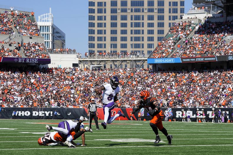 Lamar Jackson (8), quarterback de Ravens de Baltimore, corre con el balón mientras el defensive end Sam Hubbard (94), de los Bengals de Cincinnati, intenta darle alcance durante la primera mitad del juego de la NFL del domingo 6 de octubre de 2024, en Cincinnati. (AP Foto/Jeff Dean)