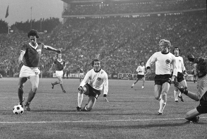 ARCHIVO - Juergen Sparwasser (izquierda) se apresta a anotar el único gol de Alemania Oriental ante Alemania Occidental en el partido del Mundial, en Hamburgo, el 22 de junio de 1974. En el centro aparece Horst-Dieter Hoettges, zaguero de Alemania Occidental. Hoettges ha fallecido. Tenía 79 años. (AP Foto)