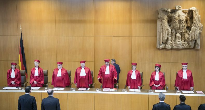 ARCHIVO - Andreas Vosskuhle, el cuarto de derecha a izquierda, presidente de la Corte Constitucional de Alemania, anuncia la decisión del máximo tribunal alemán de mantener la prohibición de las huelgas de servidores públicos, en Karlsruhe, Alemania, el martes 12 de junio de 2018. (AP Foto/Sebastian Gollnow, Pool, Archivo)