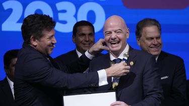 El presidente de CONMEBOL, Alejandro Domínguez, a la izquierda, condecora al presidente de FIFA, Giovanni Infantino, durante el Congreso de la entidad sudamericana en Luque, Paraguay, jueves 11 abril, 2024. (AP Foto/Jorge Saenz)