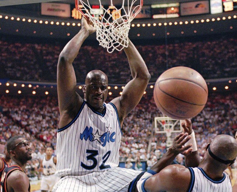 ARCHIVO - Shaquille ONeal, pívot del Magic de Orlando, cuelga del aro tras una volcada durante un partido de postemporada ante los Hawks de Atlanta, el 8 de mayo de 1996 (AP Foto/Peter Cosgrove, archivo)