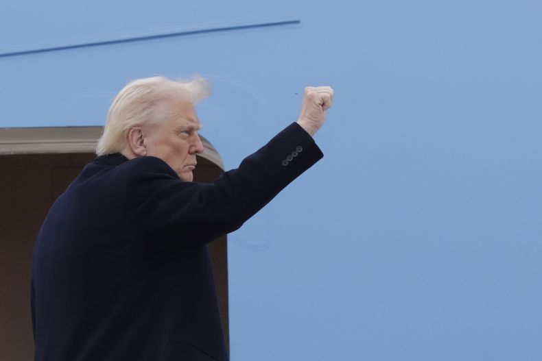 El presidente Donald Trump alza un puño antes de ingresar al Air Force One el viernes 14 de marzo de 2025, en la Base Conjunta Andrews, Maryland. (AP Foto/Luis M. Alvarez)
