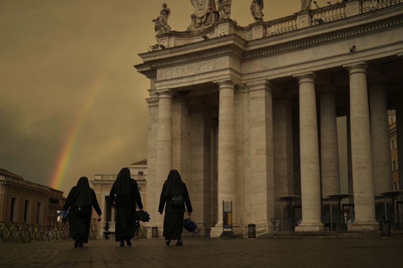 Tres monjas caminan por la Plaza de San Pedro después de un chuvasco en el cuarto día de luto por la muerte del papa Francisco, en el Vaticano, el 29 de abril de 2025. (AP Foto/Francisco Seco)