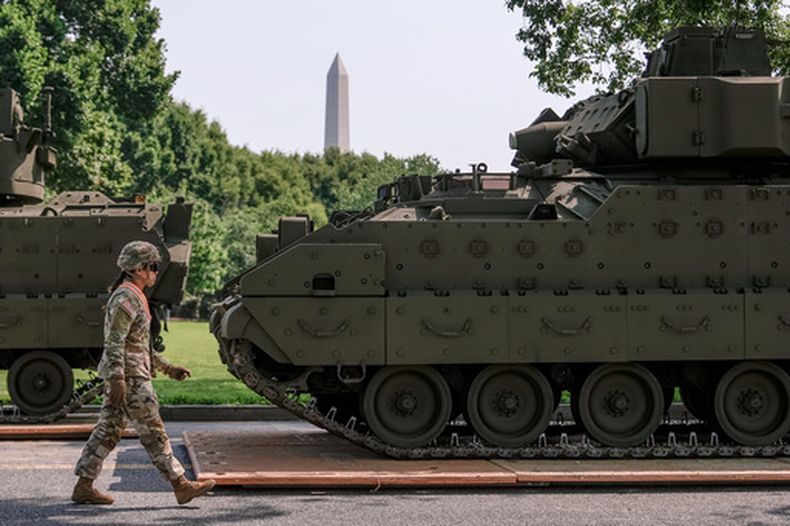 ARCHIVO - Un soldado del Ejército de Estados Unidos pasa junto a un vehículo de combate Bradley estacionado en West Potomac Park, antes del desfile militar para conmemorar el 250 aniversario del Ejército y que coincidió con el 79 cumpleaños de Donald Trump, el 11 de junio de 2025, en Washington. (AP Foto/Julia Demaree Nikhinson, archivo)