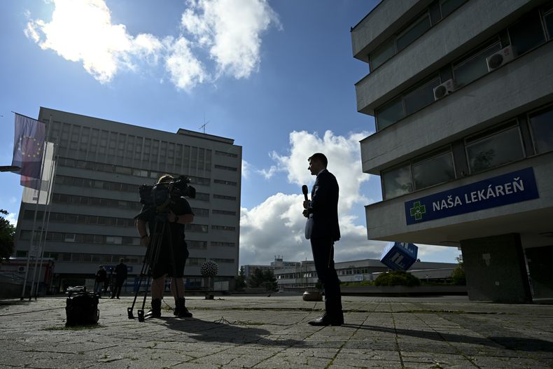 Reporteros trabajan en el exterior del hospital universitario F. D. Roosevelt, donde se atiende al primer ministro de Eslovaquia, Robert Fico, tras recibir múltiples disparos, en Banska Bystrica, Eslovaquia, el 18 de mayo de 2024. (AP Foto/Denes Erdos)