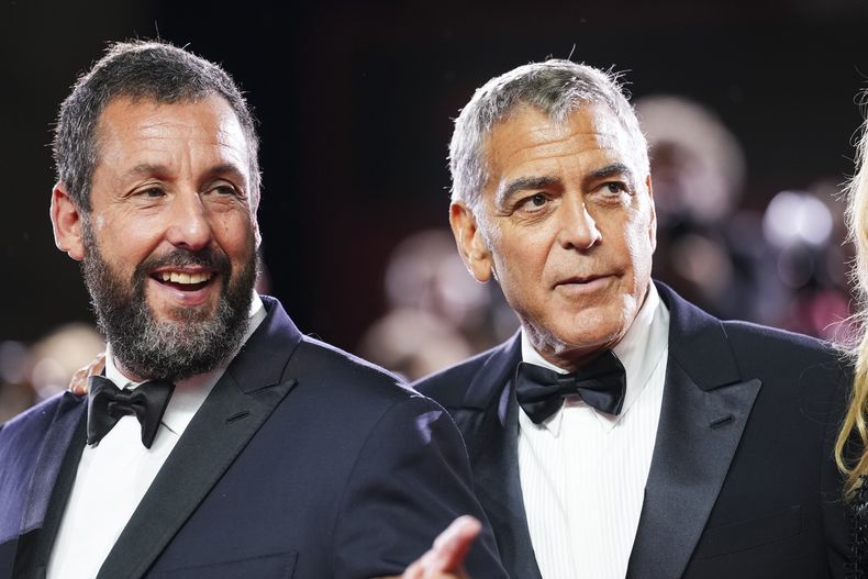 Adam Sandler, a la izquierda, y George Clooney posan para los fotógrafos en la alfombra roja de la película Jay Kelly durante la 82ª edición del Festival de Cine de Venecia en Venecia, Italia, el jueves 28 de agosto de 2025. (Foto Scott A Garfitt/Invision/AP)