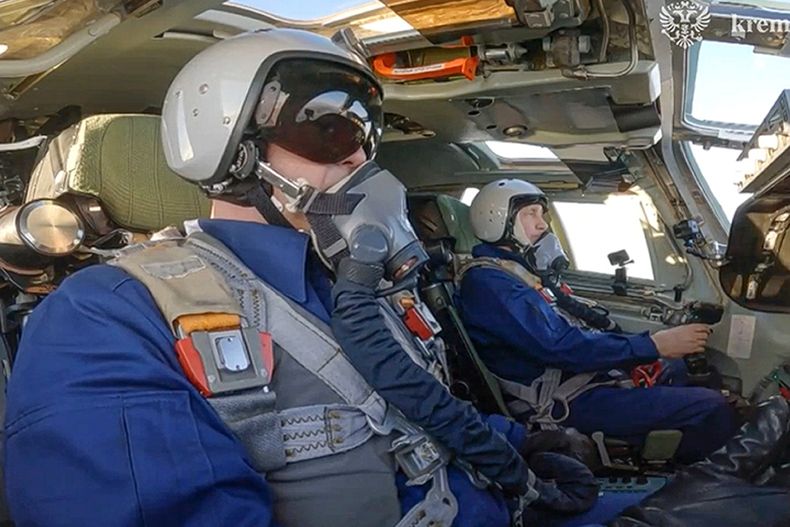 En esta foto tomada de un video publicado por el Servicio de Prensa del Kremlin, el presidente ruso Vladímir Putin, al fondo, aparece en el asiento del copiloto de un bombardero estratégico Tu-160M durante un vuelo en Rusia, el jueves 22 de febrero de 2024. (Servicio de Prensa del Kremlin vía AP)