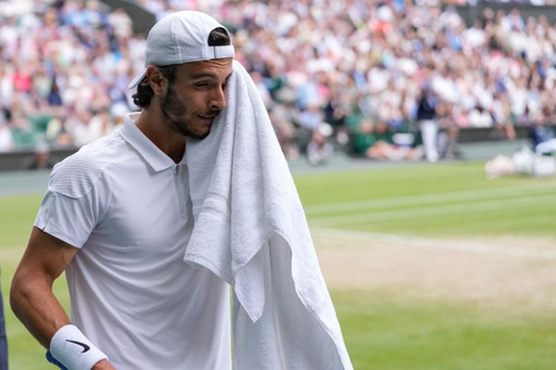 ARCHIVO - Foto del 12 de julio del 2024, el italiano Lorenzo Musetti se quita el sudor durante la semifinal de Wimbledon ante el serbio Novak Djokovic. (AP Foto/Alberto Pezzali, Archivo)
