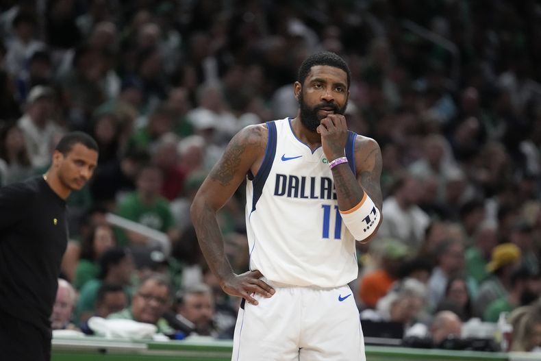 ARCHIVO - El base de los Mavericks de Dallas, Kyrie Irvinng se detien en la cancha frente al entrenador de los Celtics de Boston, Joe Mazzulla (izquierda), durante la primera mitad del quinto juego de las finales del baloncoesto de la NBA, el 17 de junio de 2024, en Boston. (AP Foto/Charles Krupa, Archivo)
