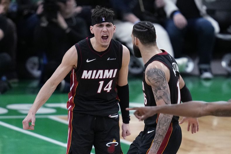 Tyler Herro (14), del Heat de Miami, festeja con Caleb Marin hacia el final del segundo partido de la serie de playoffs ante los Celtics de Boston, el miércoles 24 de abril de 2024 (AP Foto/Charles Krupa)