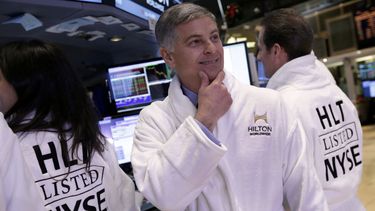 americateve | Christopher Nassetta, director general de Hilton Worldwide, al centro, posa con una bata de Hilton despu&eacute;s de que la oferta accionaria inicial de su compa&ntilde;&iacute;a comenz&oacute; a cotizarse en el piso de la Bolsa de Valores de Nueva York,