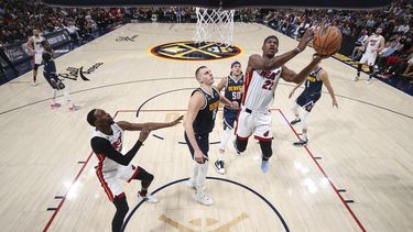 El alero del Heat de Miami Jimmy Butler lanza el balón superando al pívot de los Nuggets de Denver Nikola Jokic en el juego 2 de las Finales de la NBA el domingo 4 de junio del 2023. (Matthew Stockman/Pool Photo via AP)