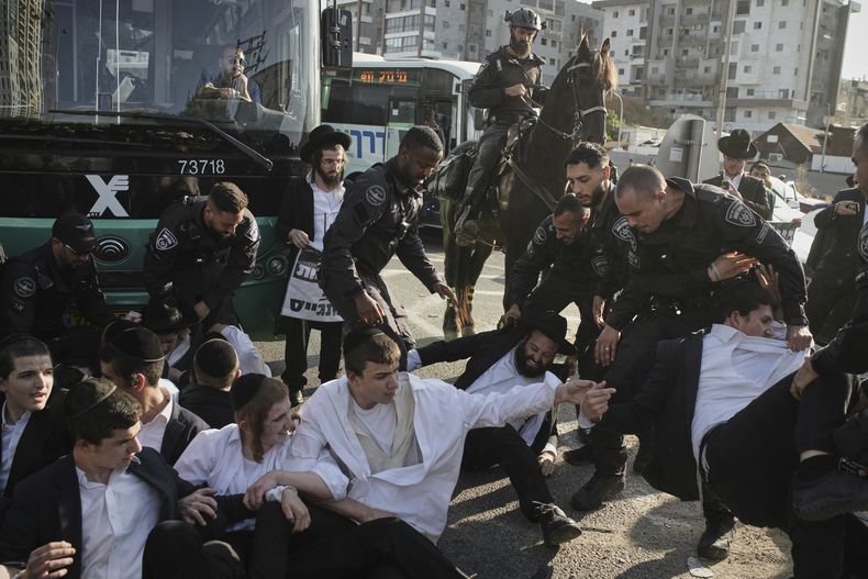 Agentes de policía israelíes dispersan a judíos ultraortodoxos durante una protesta contra su reclutamiento militar, en Bnei Brak, Israel, el 5 de junio de 2025. (AP Foto/Leo Correa)