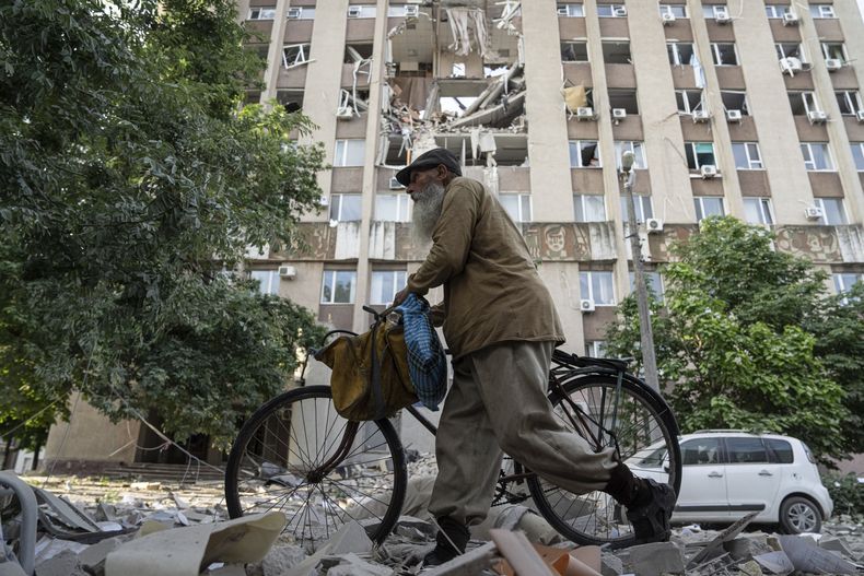 Un hombre pasa por delante de un edificio con graves daños tras un ataque aéreo ruso sobre Jersón, Ucrania, el 15 de junio de 2023. (AP Foto/Evgeniy Maloletka)