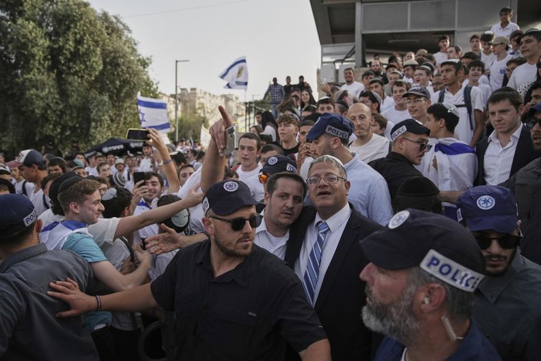 Rodeado de guardias de seguridad, el ministro de Seguridad Nacional de Israel, el ultraderechista Itamar Ben-Gvir, centro, participa en una marcha conmemorativa del Día de Jerusalén, en la Puerta de Damasco de la Ciudad Vieja de Jerusalén, el lunes 26 de mayo de 2025. (AP Foto/Leo Correa)