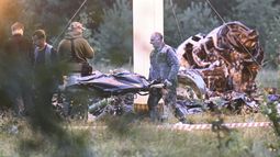 Dos personas trasladan una bolsa para cadáveres del lugar donde se estrelló un avión privado, cerca de la localidad de Kuzhenkino, en la región de Tver, Rusia, el 24 de agosto de 2023. (AP Foto)