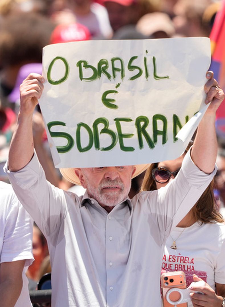 El presidente brasileño Luiz Inácio Lula da Silva sostiene un letrero en el que se lee en portugués: Brasil es un país soberano, durante un mitin de campaña previo a la segunda vuelta de las elecciones presidenciales en el barrio de Ceilândia, en Brasilia, Brasil, el viernes 9 de octubre de 2026. (AP Foto/Eraldo Peres)