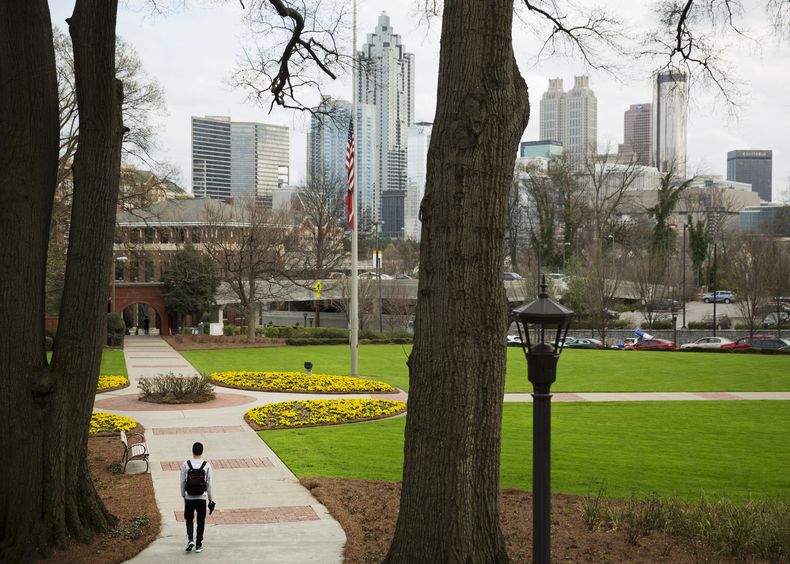 ARCHIVO - Una persona camina por el campus del Instituto de Tecnología de Georgia con el horizonte del centro de la ciudad de fondo, el 11 de marzo de 2016, en Atlanta. (AP foto/David Goldman, archivo)